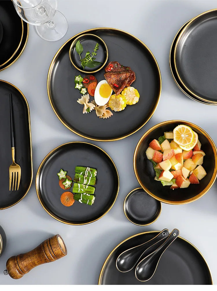 Set of matte gold inlay black porcelain dinnerware by MC THE BLACK DIAMOND, including plates and bowls for elegant kitchen use.