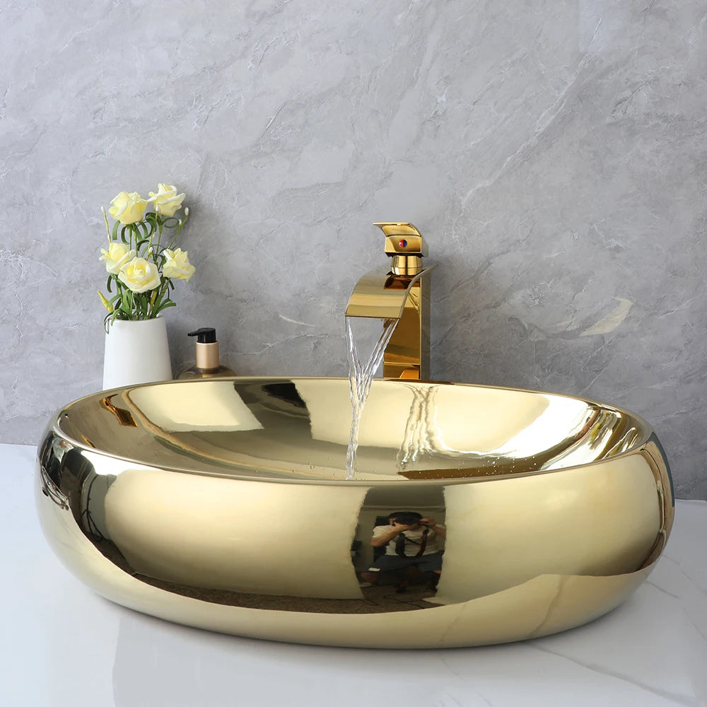 Luxury 23-inch KEMAIDI gold ceramic bathroom vessel sink with oval shape and gold waterfall faucet mixer, above-counter design.