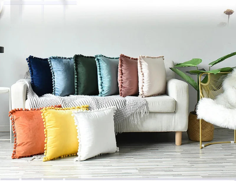 Black velvet throw pillow cover by MC THE BLACK DIAMOND featuring large pom-poms, soft texture, and cozy design for sofa décor.