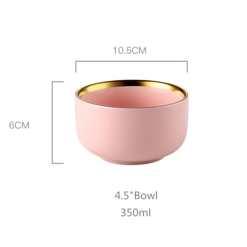 Pink porcelain dinner plate with gilt rim from MC The Black Diamonds, featuring a smooth ceramic surface and elegant design.