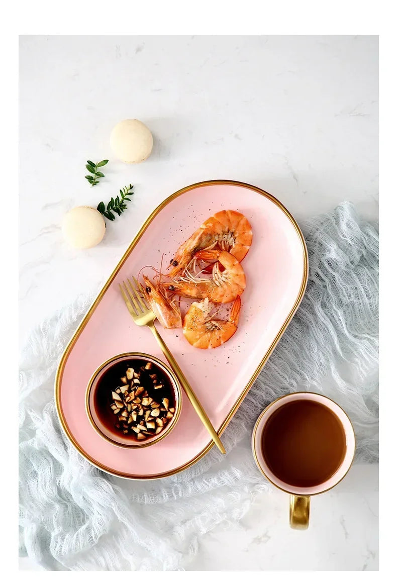 Gilt rim pink porcelain dinner plate from MC The Black Diamonds, featuring a ceramic dinnerware design with a decorative pink border.