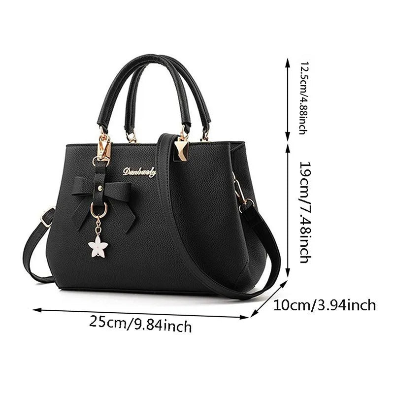 Women messenger bag with flower pendant, black leather tote from MC The Black Diamonds, featuring a crossbody strap and elegant design.