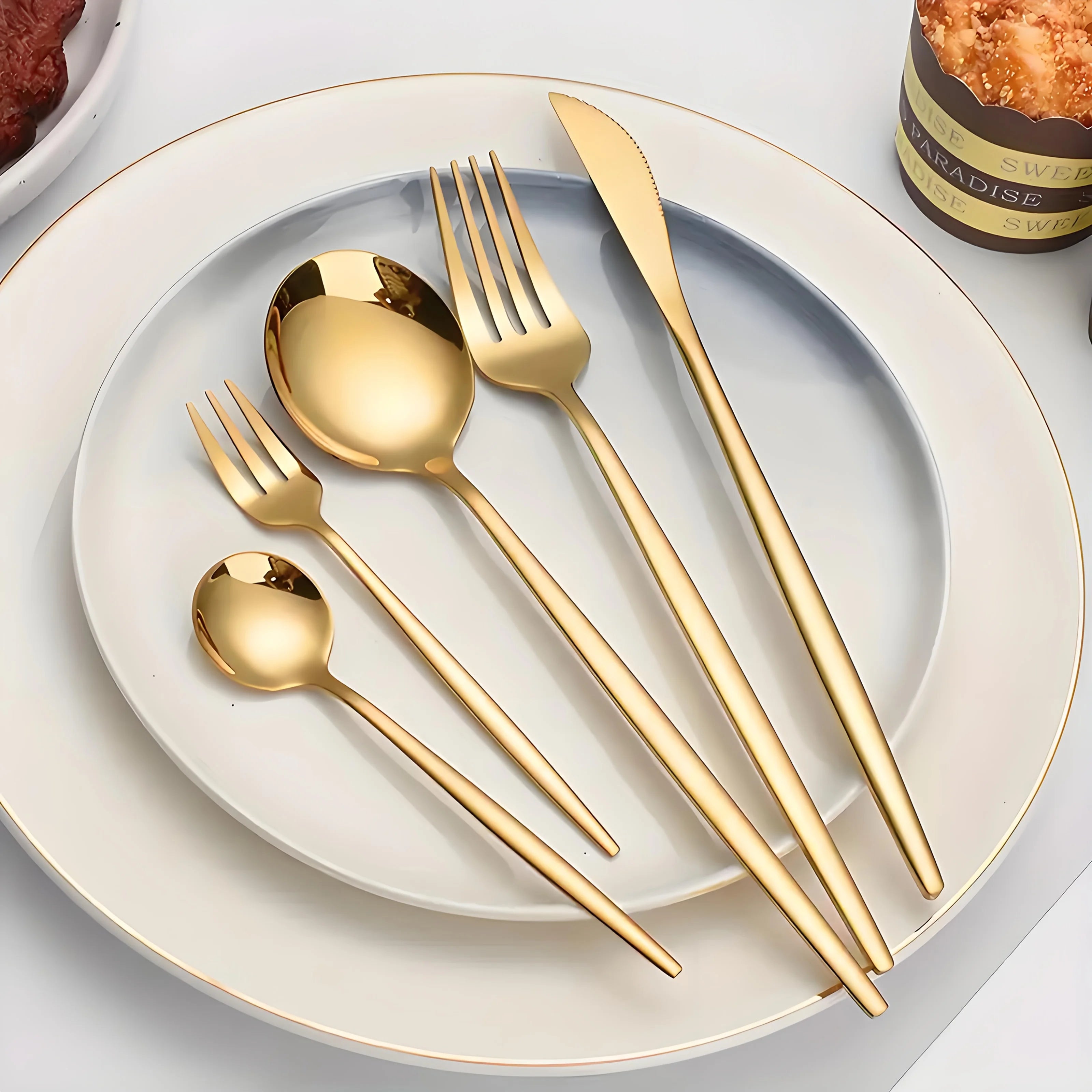 Set of 30 golden and silver cutlery pieces from MC The Black Diamonds, including forks, knives, and spoons arranged on a table.