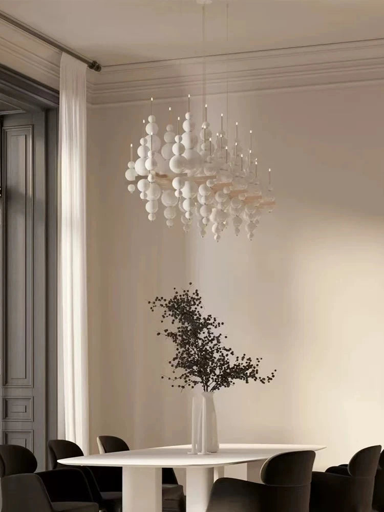 Black chandelier by MC THE BLACK DIAMOND featuring tear-shaped design, hanging from ceiling in a luxurious living room setting.
