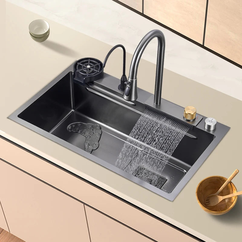 Black stainless steel kitchen faucet with waterfall spout, soap dispenser, single bowl sink, and cup washer in a modern design.