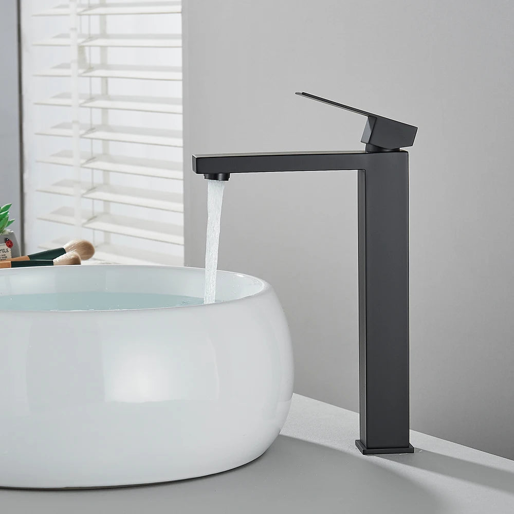 Matte black stainless steel bathroom sink faucet with cold and hot water handles, deck-mounted waterfall design by 𝕄𝕮 𝕋𝕙𝕖 𝔹𝕝𝕒𝕔𝕜 𝔻𝕚