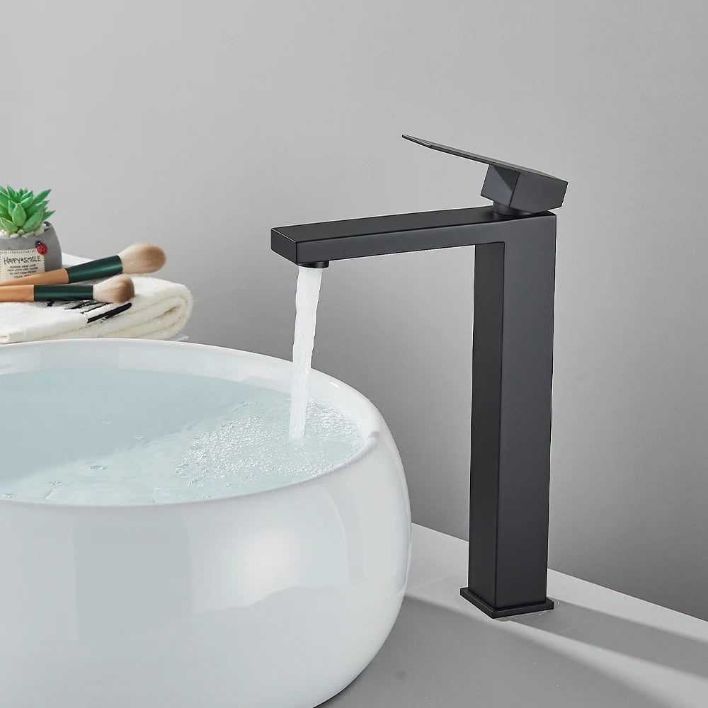 Matte black stainless steel bathroom sink faucet with hot and cold handles, deck-mounted waterfall mixer tap by 𝕄𝕔 𝕋𝕙𝕖 𝔹𝕝𝕒𝕔𝕜 𝔻𝕚