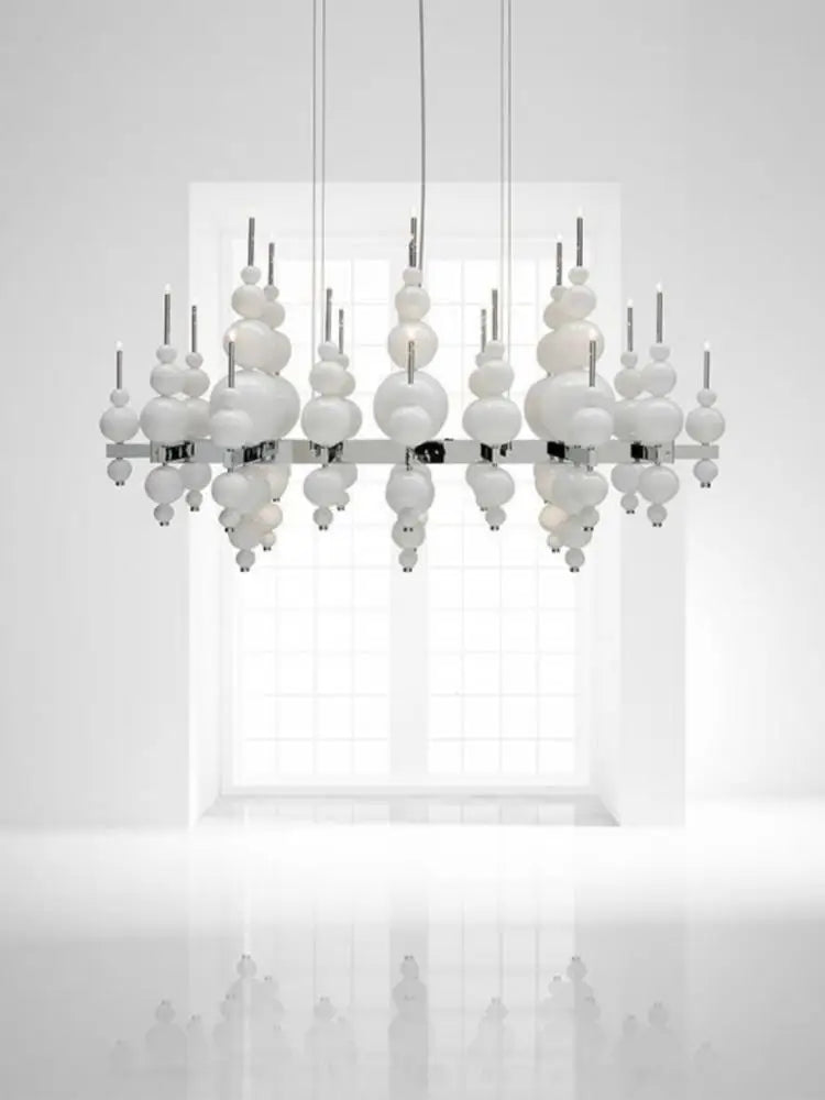 Luxury MC THE BLACK DIAMOND black chandelier with tear-shaped moon design hanging from ceiling in a stylish living room setting.